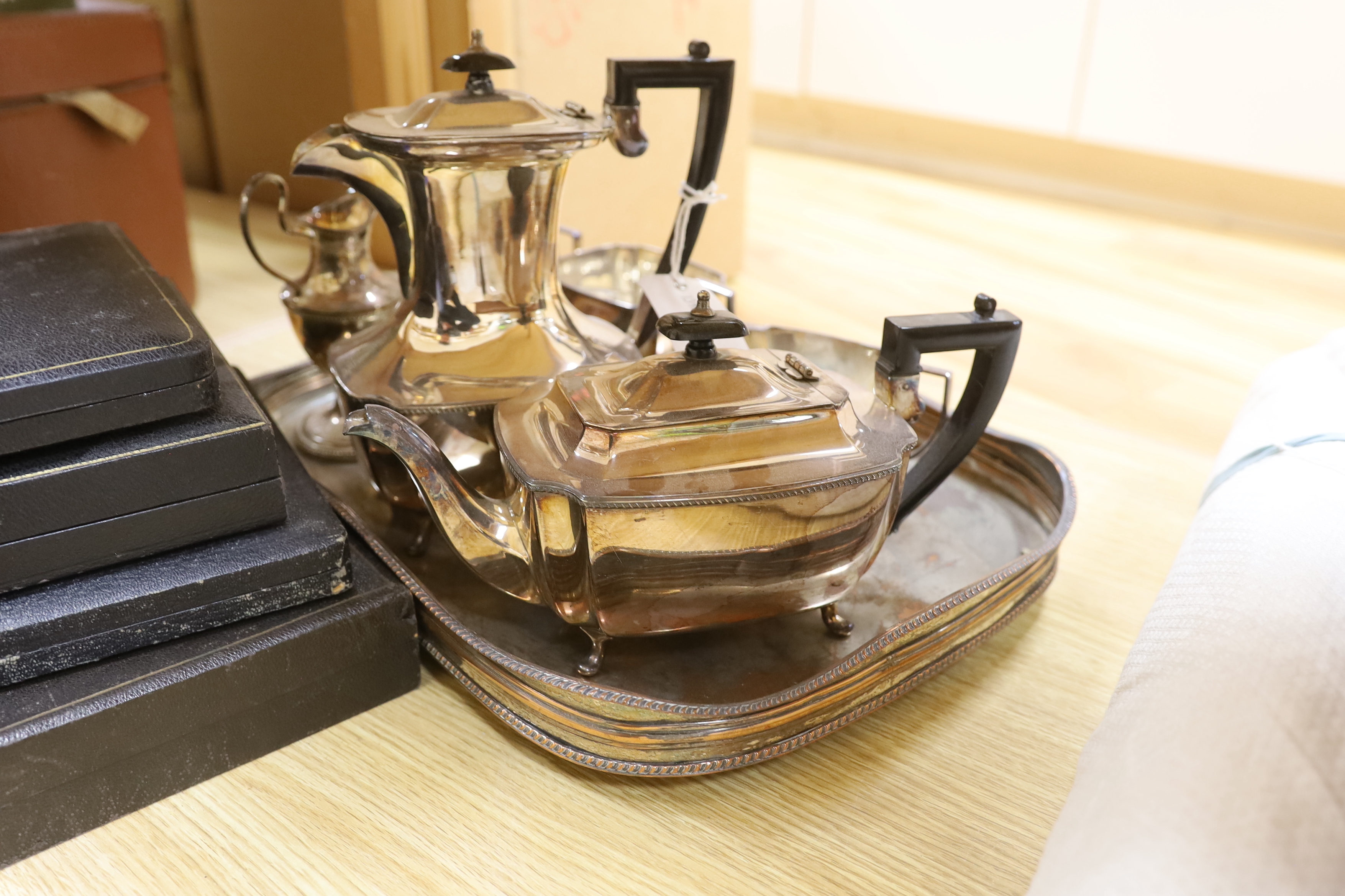 A four piece plated tea set, jug, coaster, tray and five boxed of cutlery